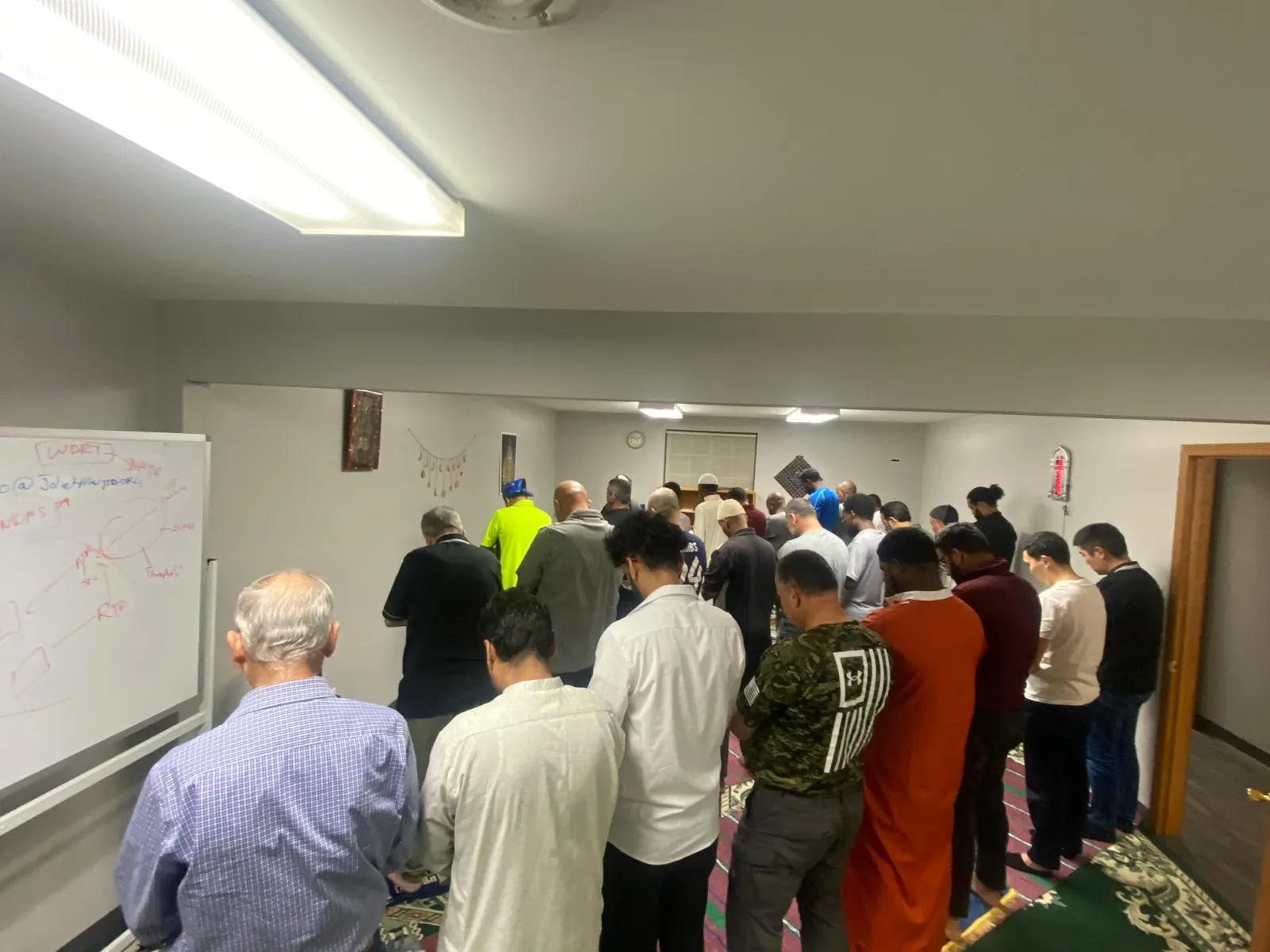 A full row of worshippers praying together